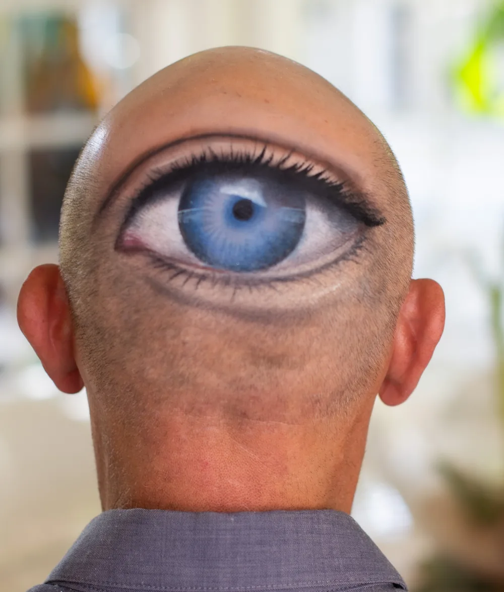 Painted cyclops eye illusion over a bald cap