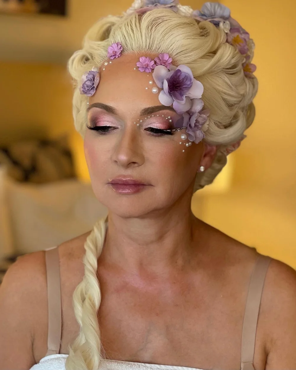 Soft pastel glam with a floral headpiece and jewelled cheekbones