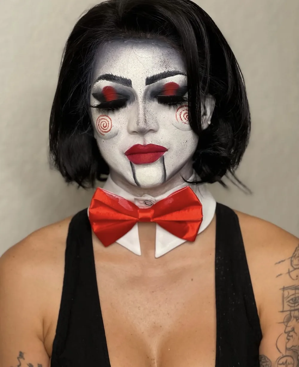 Black and white puppet character with red spirals