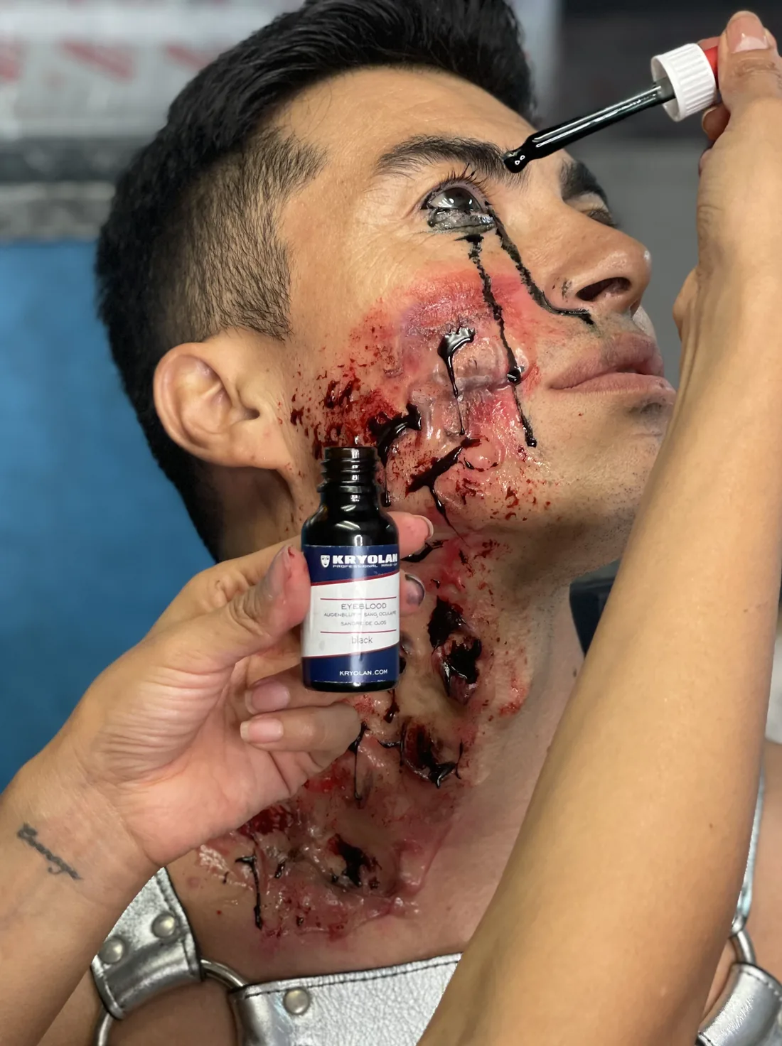 Carolina applying blood and wound effects to a client's face